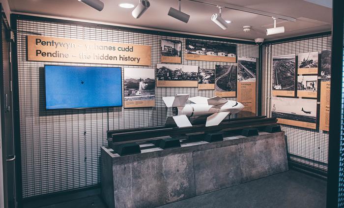 A small room with a white missile on a pedestal and rail in the centre. Metal walls display interpretation panels and photos.